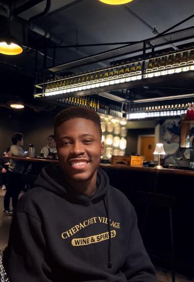 Man in dark hoodie sitting in a bar
