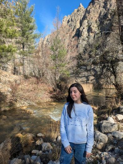 Student standing in forest