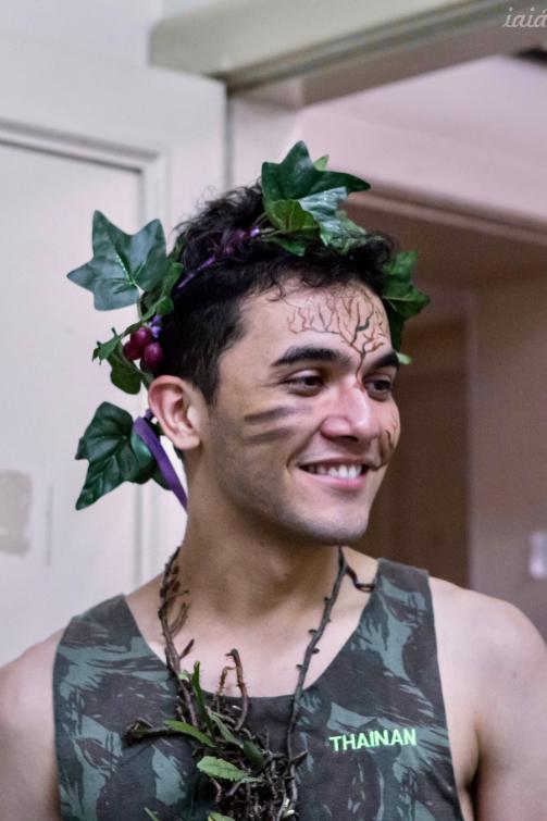 Student in vest with face paint and a leaf head-dress