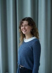 Student smiling by blue curtains