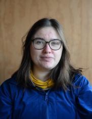 Student with glasses, long hair and blue shirt