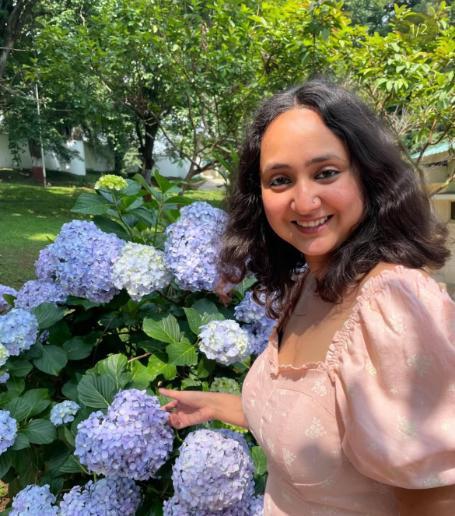Student smiling by flowers