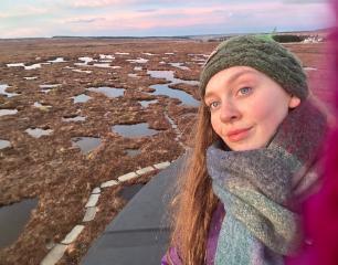 Student posing by large bodies of water