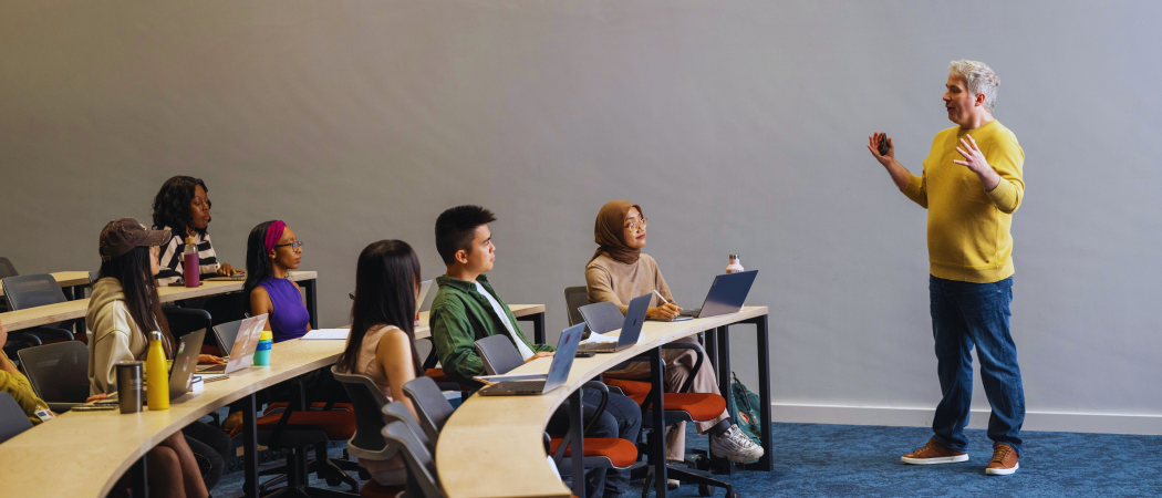 A diverse group of students in a teaching room with a lecturer at the front