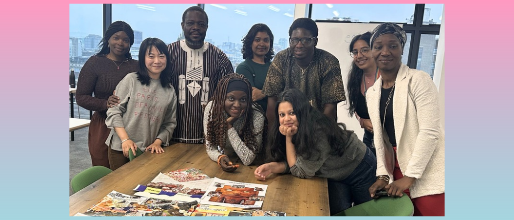Group of participants gathered around a table displaying collage artworks and magazine cuttings during a Black History Month collage workshop.