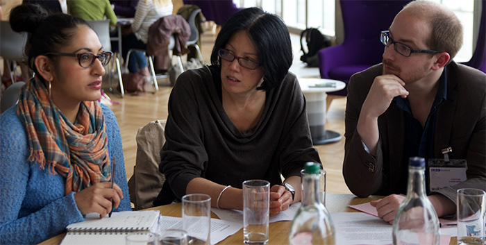 Three researchers discuss work at an event