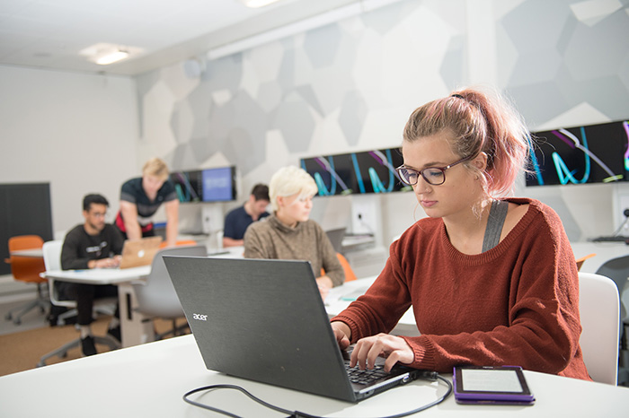 A researcher works at a laptop in a high-tech looking room